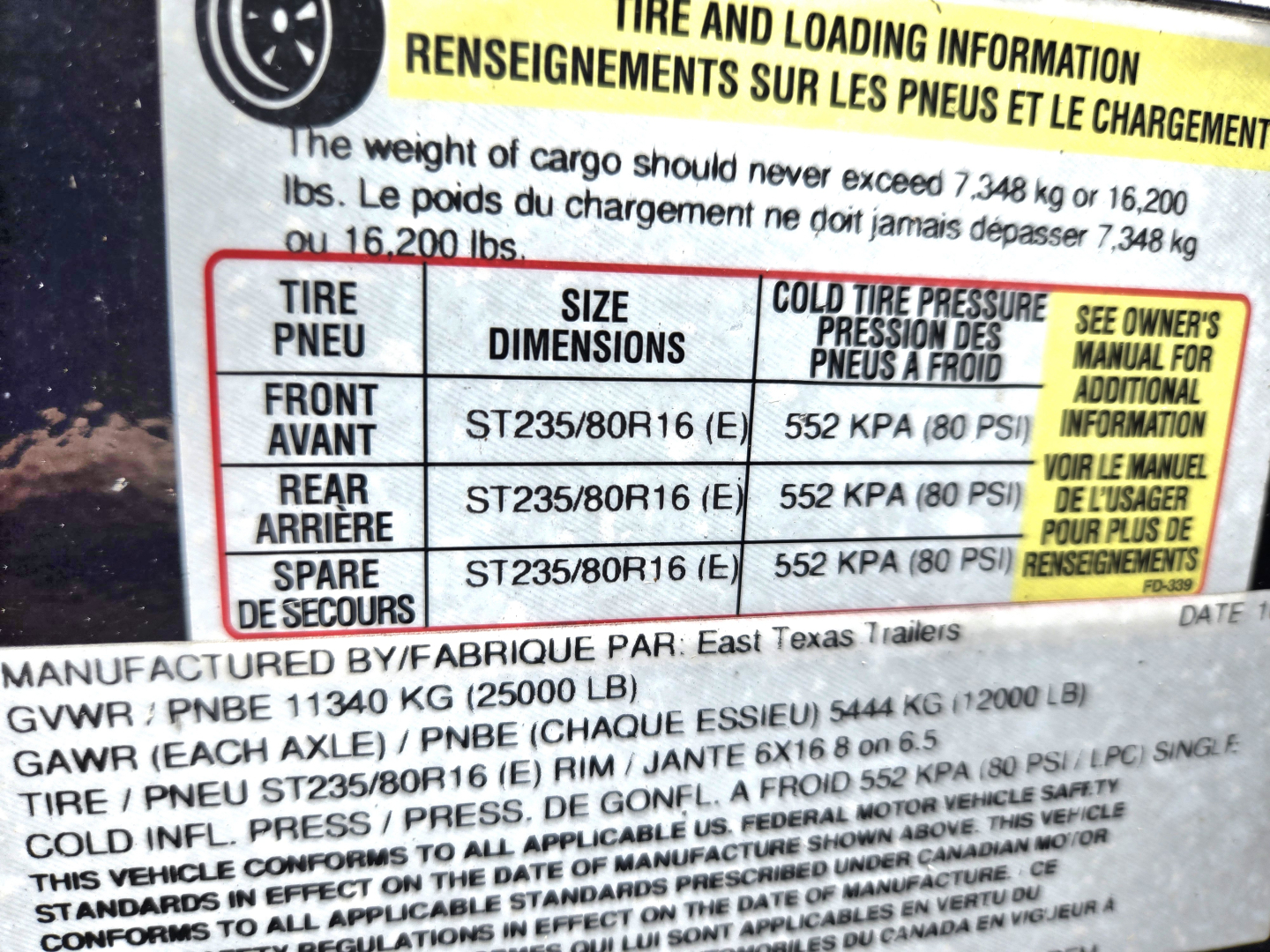 Trailer axle and tire information sticker showing tire sizes ST235/80R16 and cold tire pressure 552 KPA (80 PSI) with GVWR and GAWR details partially visible.
