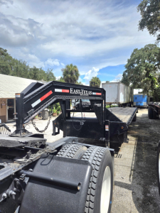 Trailer chassis showing East Texas GOOSENECK 40 ft flatbed with ramps and black steel frame.