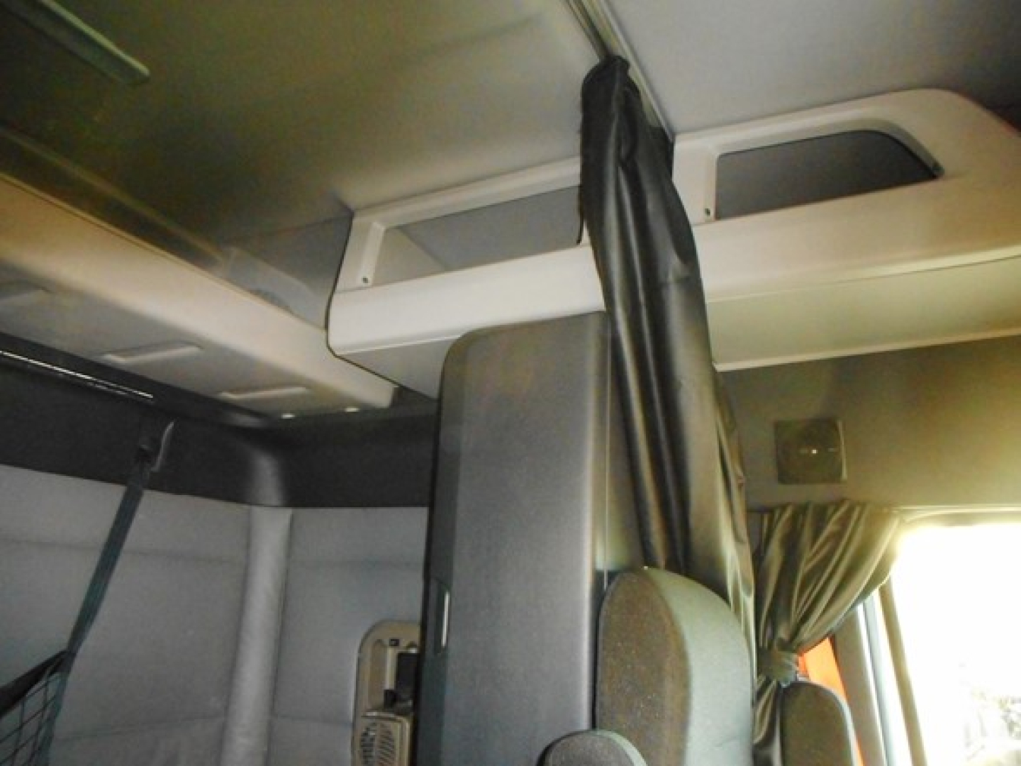 Cab interior of a 2022 Freightliner Cascadia 116 sleeper truck showing driver's seat and partition.