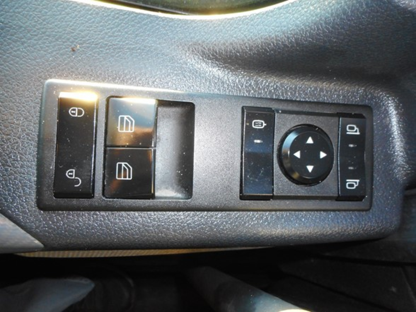 Freightliner Cascadia interior switch panel showing window controls and mirror/directional pad.