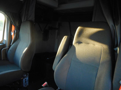 Freightliner Cascadia driver cabin with seating; visible panels and seat fabric. No engine or labels clearly legible.