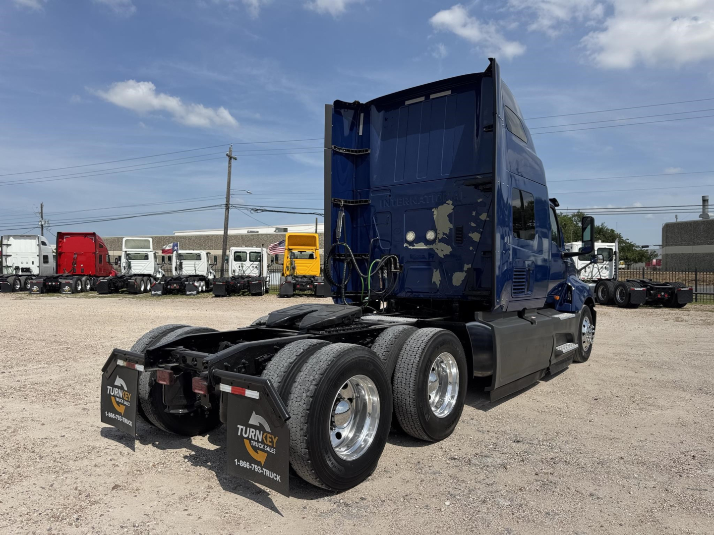 Truck rear and cab of a blue 2020 International LT in a dealership lot, showing the fifth-wheel gap, dual rear axles, and tires; stock number B2988P visible.