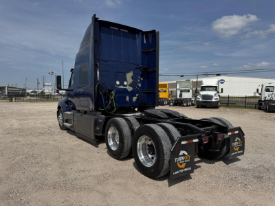 Truck chassis and sleeper cab of a 2020 International LT in rear three-quarter view showing dual rear axles and mud flaps.