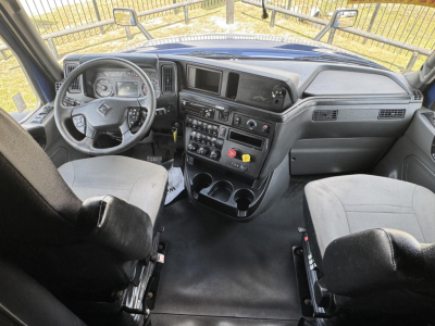 Truck interior showing dash with steering wheel, center console, and seating; gauges and controls visible in International LT 2020 cabin.