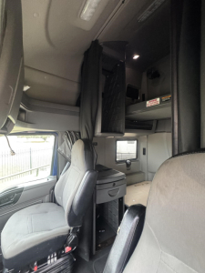 Truck cab interior of a used 2020 International LT with sleeper, showing bunk area, overhead storage, curtains, and driver/passenger seats.