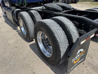 Truck axles and dual rear tires of a 2020 International LT in a sleeper tractor configuration showing dual rear wheels and mud flaps.