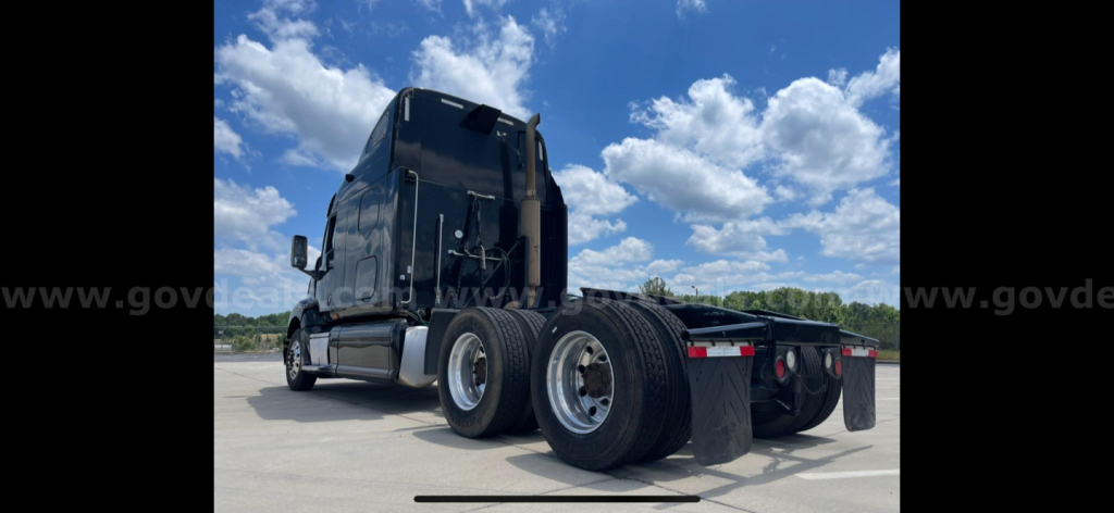 Rear view of a 2009 Peterbilt 387 tractor with dual rear axles and wheels visible, showing the back of the cab and chassis.