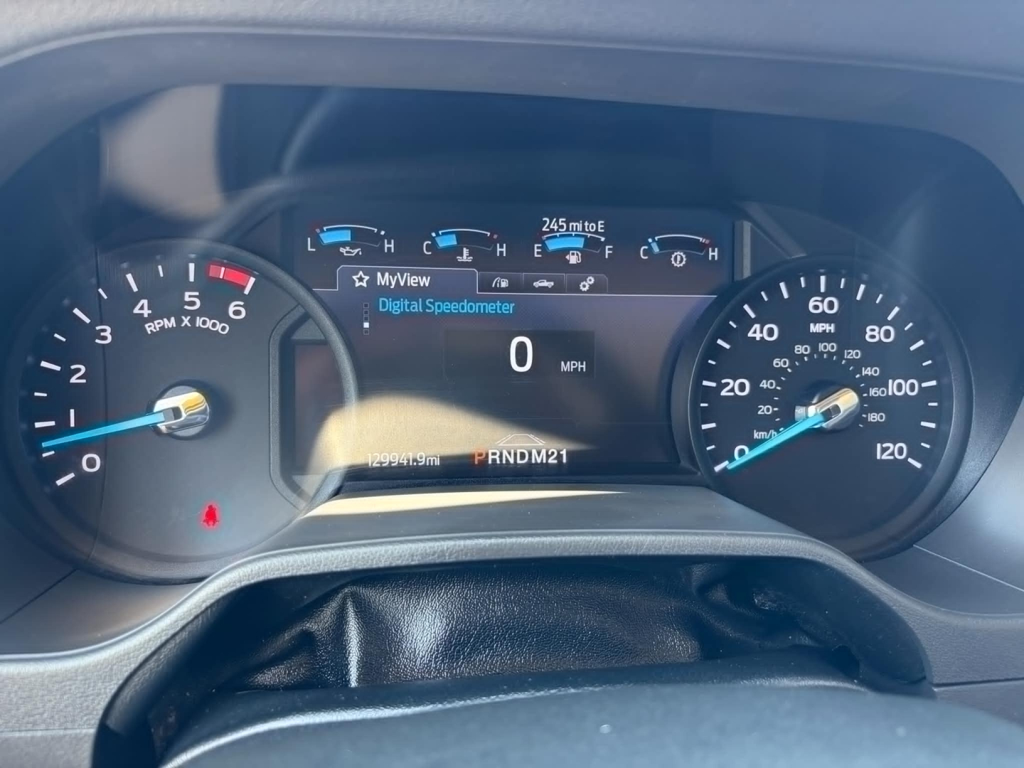 Dashboard of a 2022 Ford E350 showing digital speedometer reading 0 mph, gear indicator PRNDM21, left tachometer, right speed gauge, and various indicator icons.