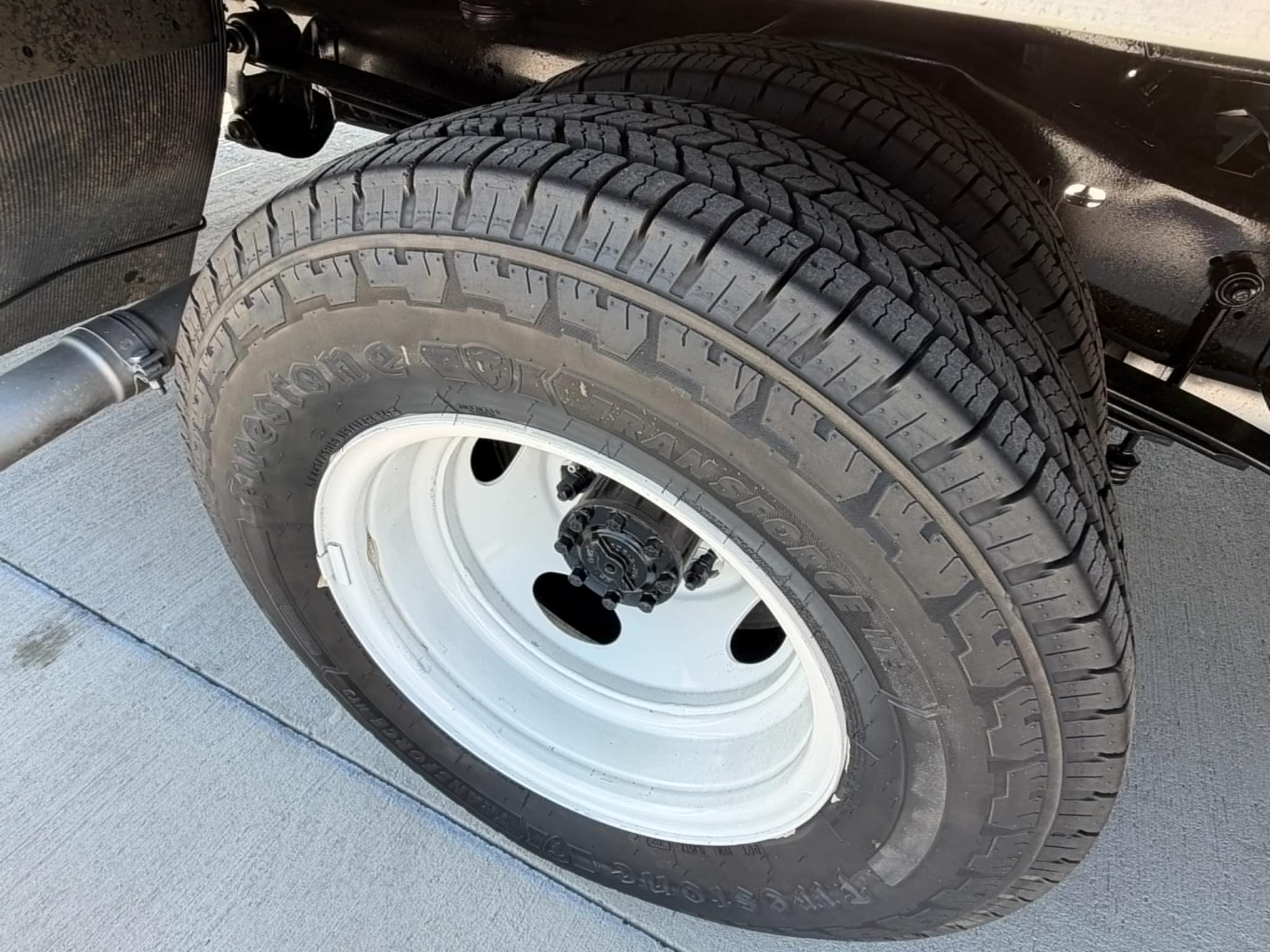 Wheel and tire close-up on a 2022 Ford E350 chassis. Visible text on tire reads generic tread pattern and tire brand, no engine data visible.