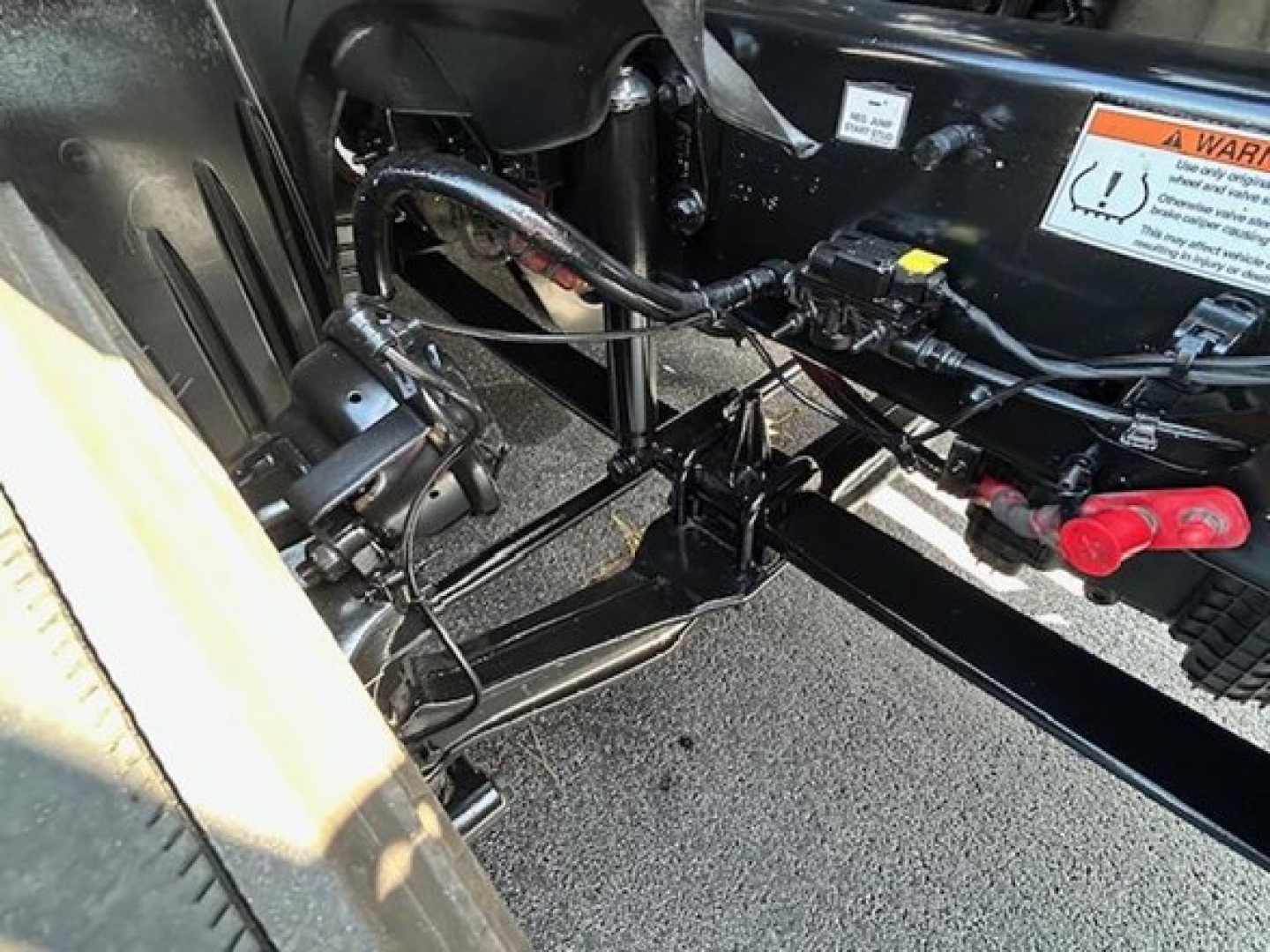 Truck chassis showing electrical harness and frame near cab mounting on a 2022 Freightliner Cascadia 126.
