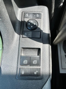 Truck interior control panel showing window lock and mirror adjustment switches on a Freightliner Cascadia 126 image.