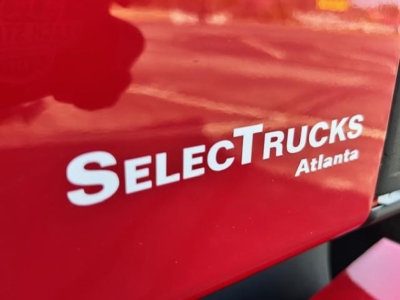 Freightliner Cascadia sleeper cab truck image showing SelectTrucks Atlanta branding on red exterior.