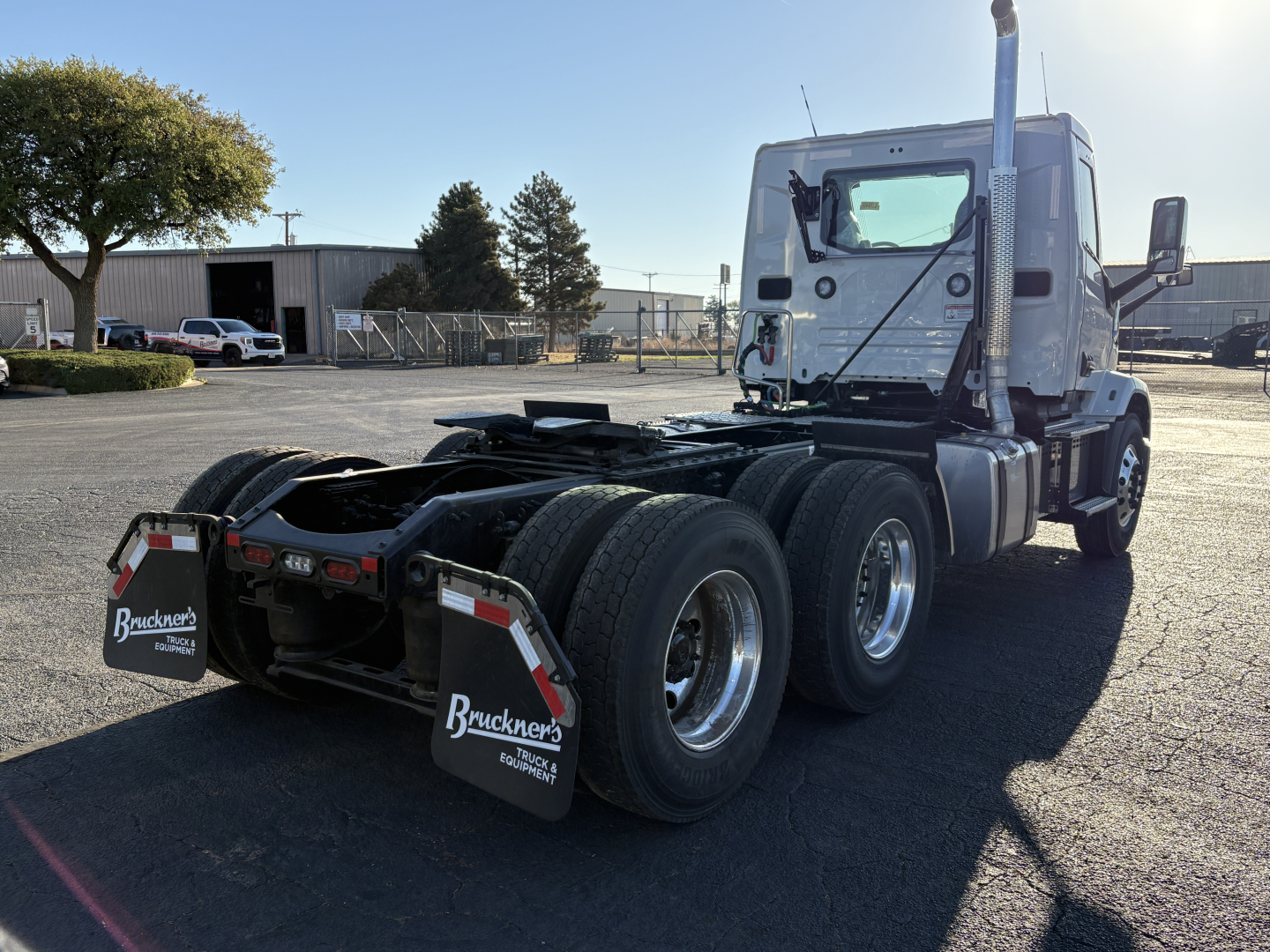 Semi truck cab and chassis rear view showing dual rear axles, fifth wheel area, and mud flaps with Buckner’s logo.