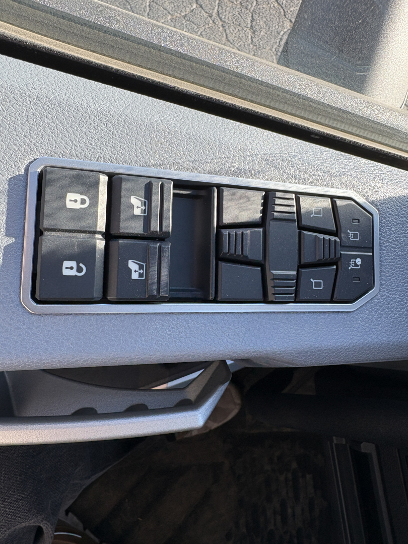Truck interior door panel with window/lock controls; four window buttons, lock switch icons visible