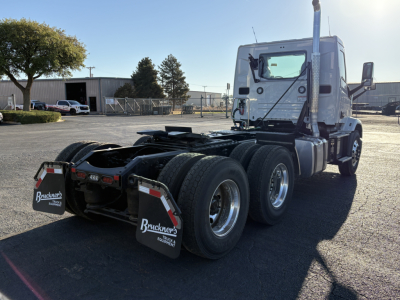 Semi truck cab and chassis rear view showing dual rear axles, fifth wheel area, and mud flaps with Buckner’s logo.