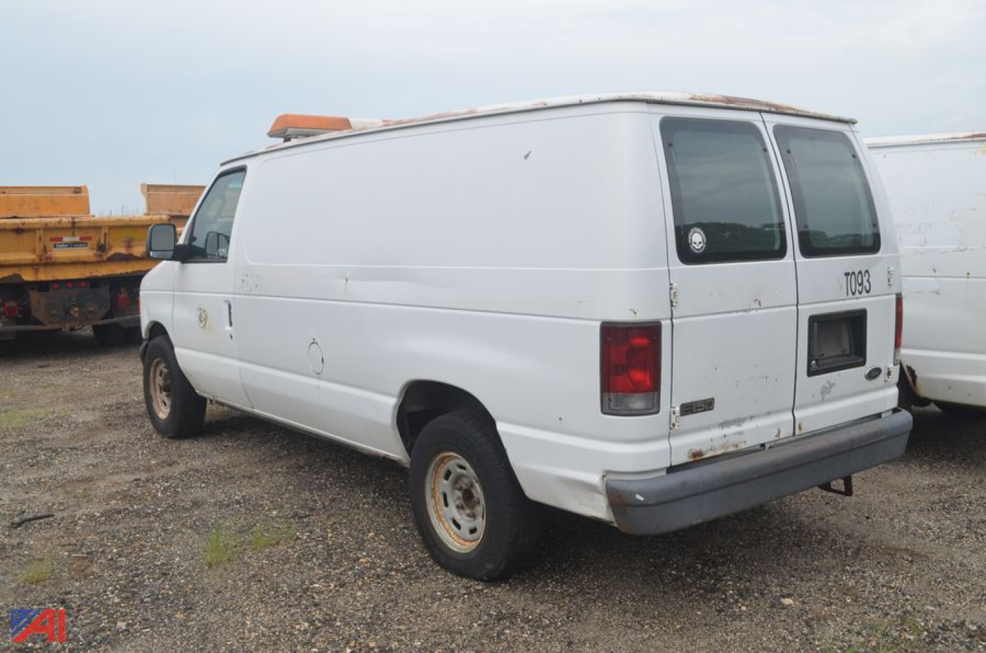 Ford Econoline cargo van rear-left view showing plain white body, rear doors, and faded taillights.