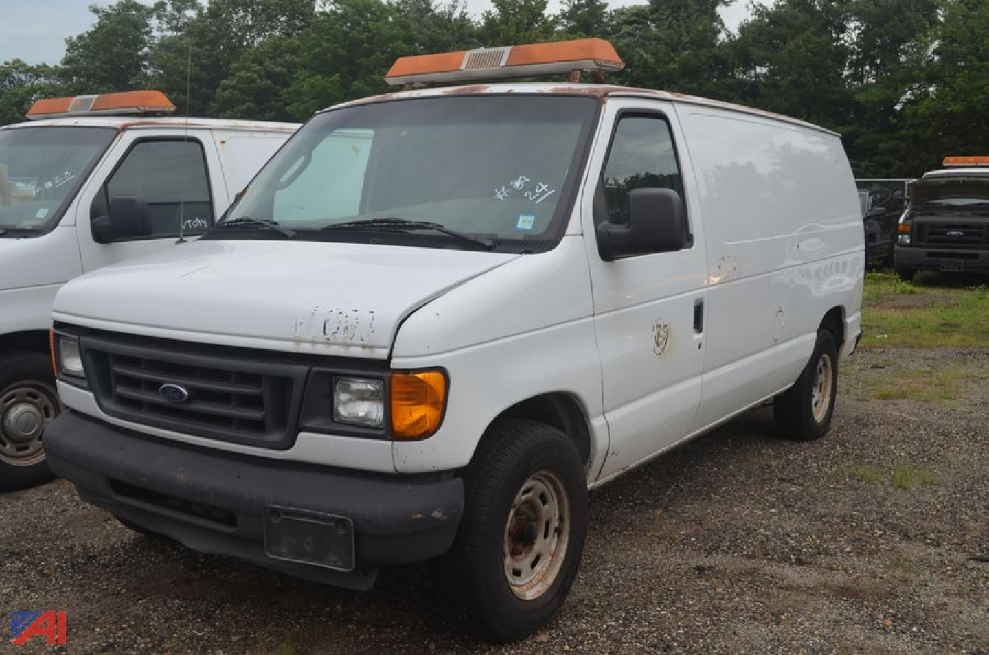 Ford Econoline cargo van 2004 in-service white with orange light bar on roof, front grille, headlights, and black bumper.