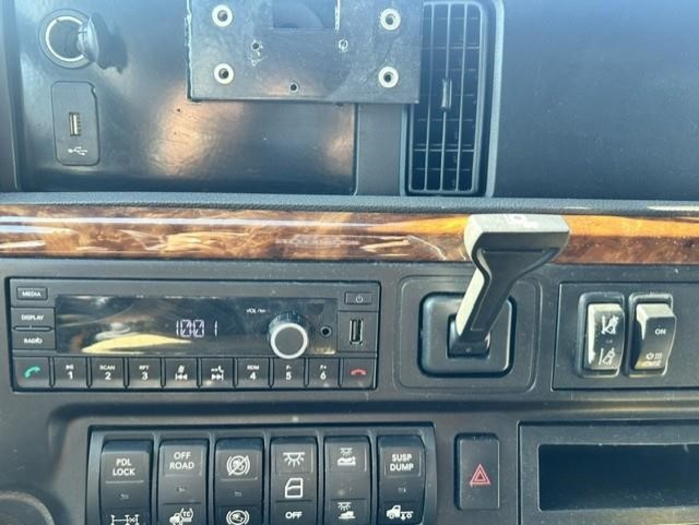 Truck dashboard from a 2021 International LT showing control panel, gear shifter, media display, and wood trim.
