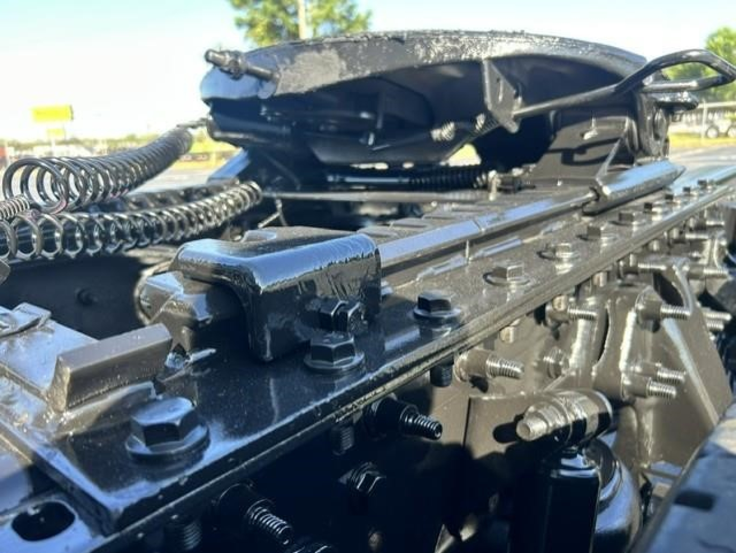 Trailer hitch area and frame of a used 2021 International LT sleeper tractor showing mounting hardware and hydraulic lines.