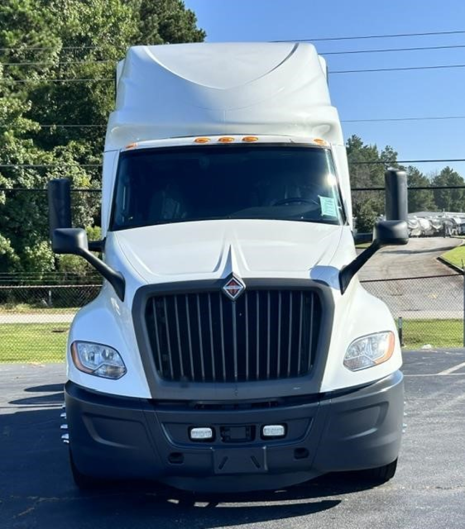 Truck front view showing grille, headlights, and bumper of a white 2021 International LT conventional sleeper.