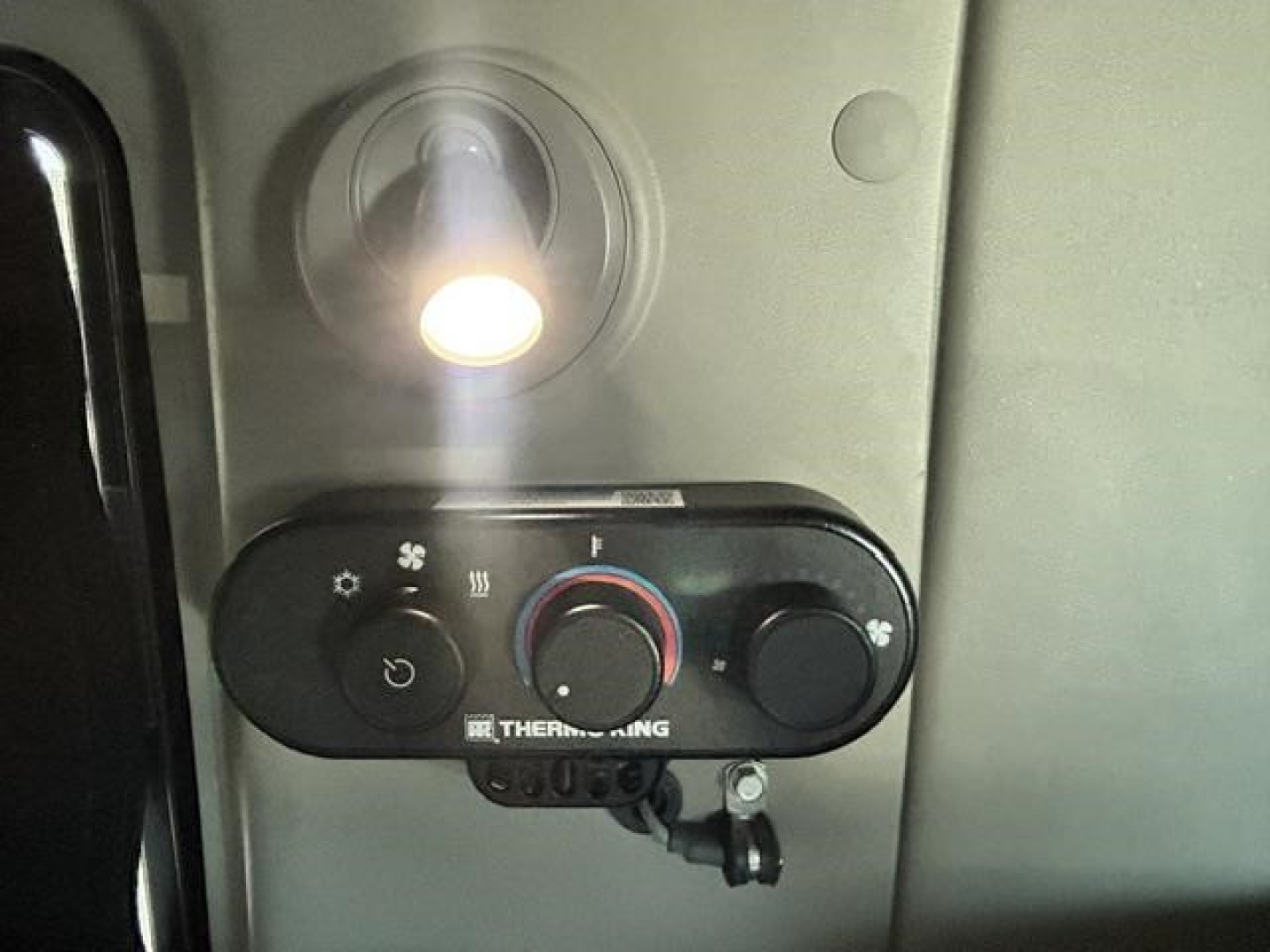 TruKTrk cab control panel with circular knobs and display showing climate controls, in-service interior of a sleeper truck.