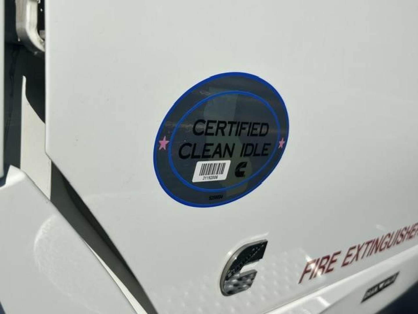 Truck rear showing Certified Clean Idle badge and partial 'Fire Extinguish' lettering on white exterior.