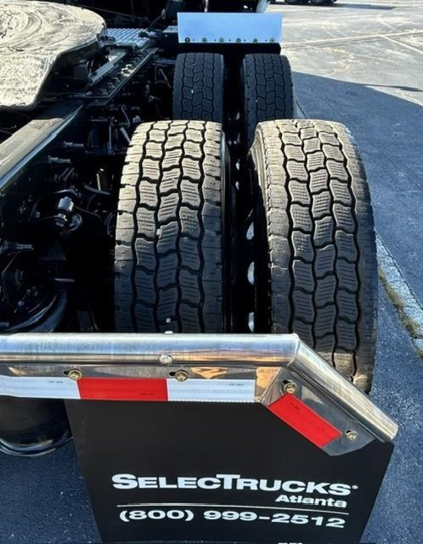 Malcolm International LT truck rear dual tires view showing SelectTrucks Atlante plate with phone number