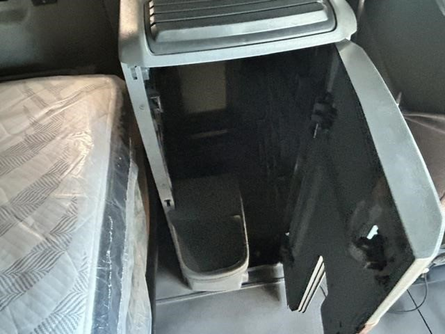 Interior of a 2021 International LT sleeper cab showing the center console and open storage area between seats.