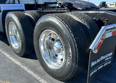 Truck rear dual tires on a sleeper tractor showing alloy wheels and Michelin tires with chrome hubcaps.