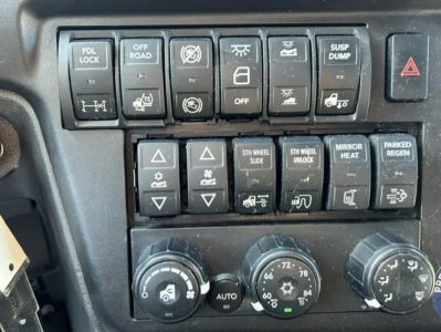 Dashboard control panel of a 2021 International LT truck showing multiple switches and climate controls.