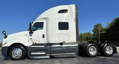 Truck side view showing heavy-duty tractor with sleeper cab and dual rear axles.