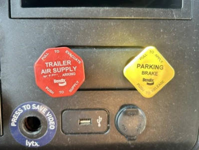 Red trailer air supply knob labeled TRAILER AIR SUPPLY Bendix with PULL TO EVACUATE and PUSH TO SUPPLY; yellow PARKING BRAKE Bendix knob with PULL TO RELEASE; blue LYTX press to save video circular port; USB port in middle; round black cap 
