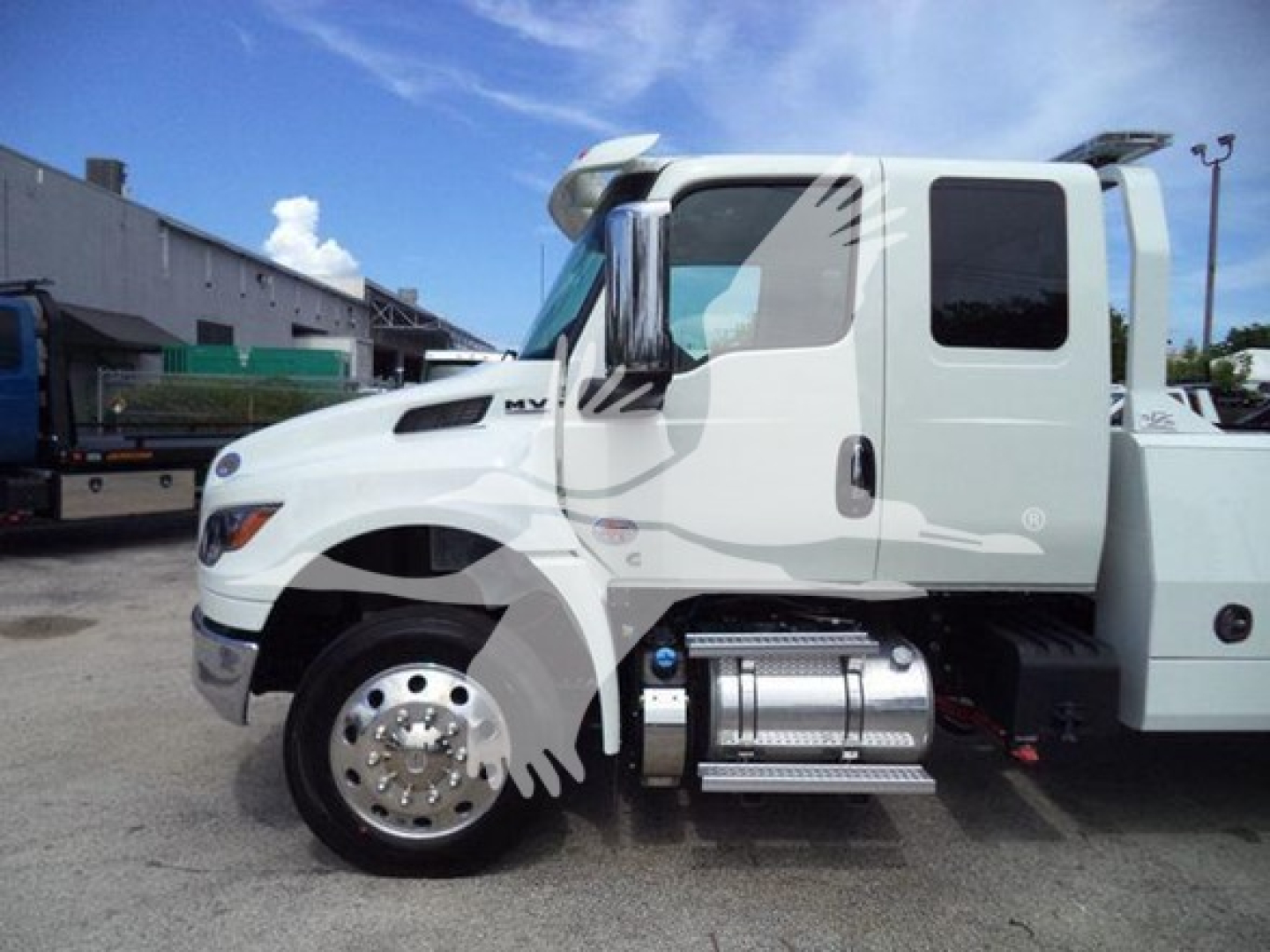 International MV truck cab side view showing fuel tanks and chrome steps with winch category label.