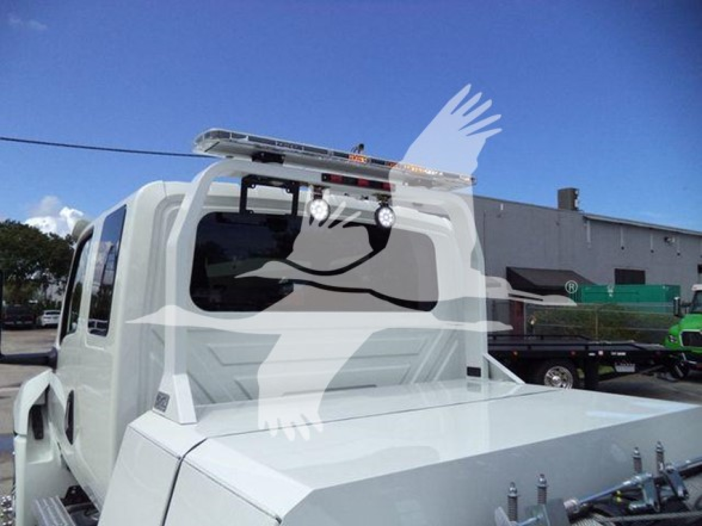 Winch-equipped 2025 International MV truck cab with rear bed, chrome rails, and roof-mounted light bar.