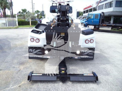 Truck rear view showing winch and hitch assembly mounted on International MV, with tow hook and bumper supports visible.