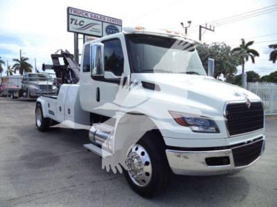 International tow truck in white cab showing front grille and side profile with winch bed.
