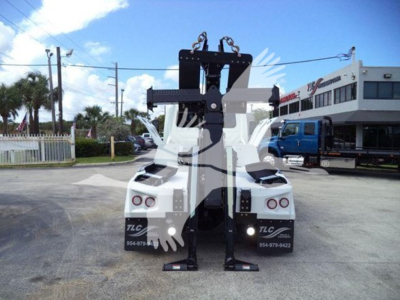 Tow vehicle with heavy-duty winch rack and dual white trucks; visible text includes TLC Florida contact numbers on rear bumper and a VIN/stock number in listing context.