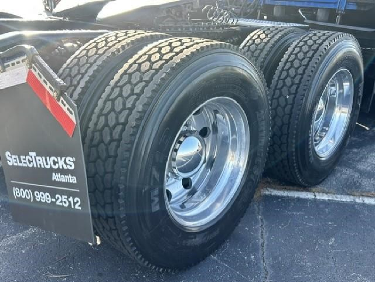 Freightliner Cascadia 126 rear axles with dual tires and polished rims, rear fender mud flaps, SelectTrucks Atlanta tag