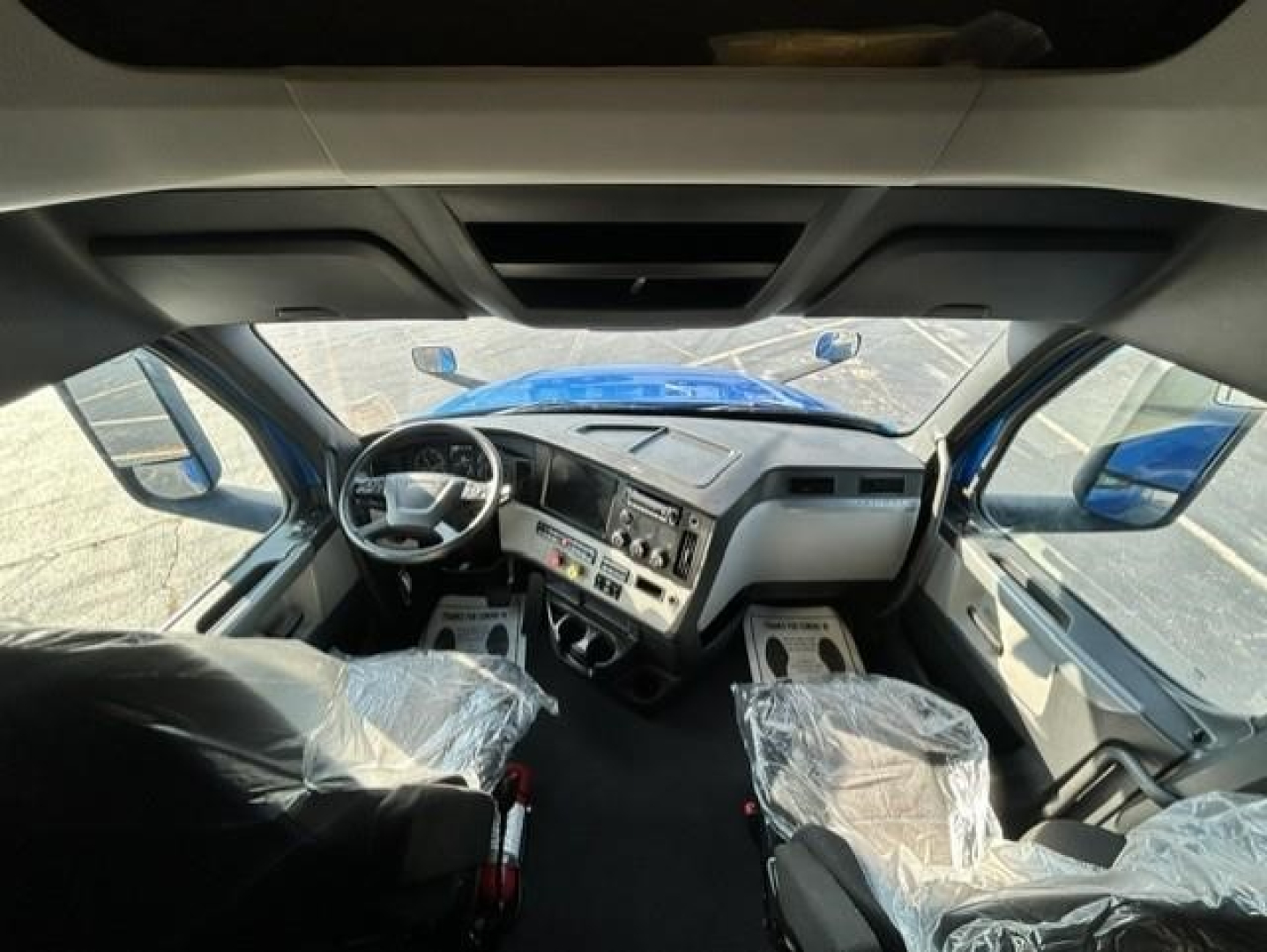 Cab of a 2022 Freightliner Cascadia 126 truck showing steering wheel dashboard and seating area.