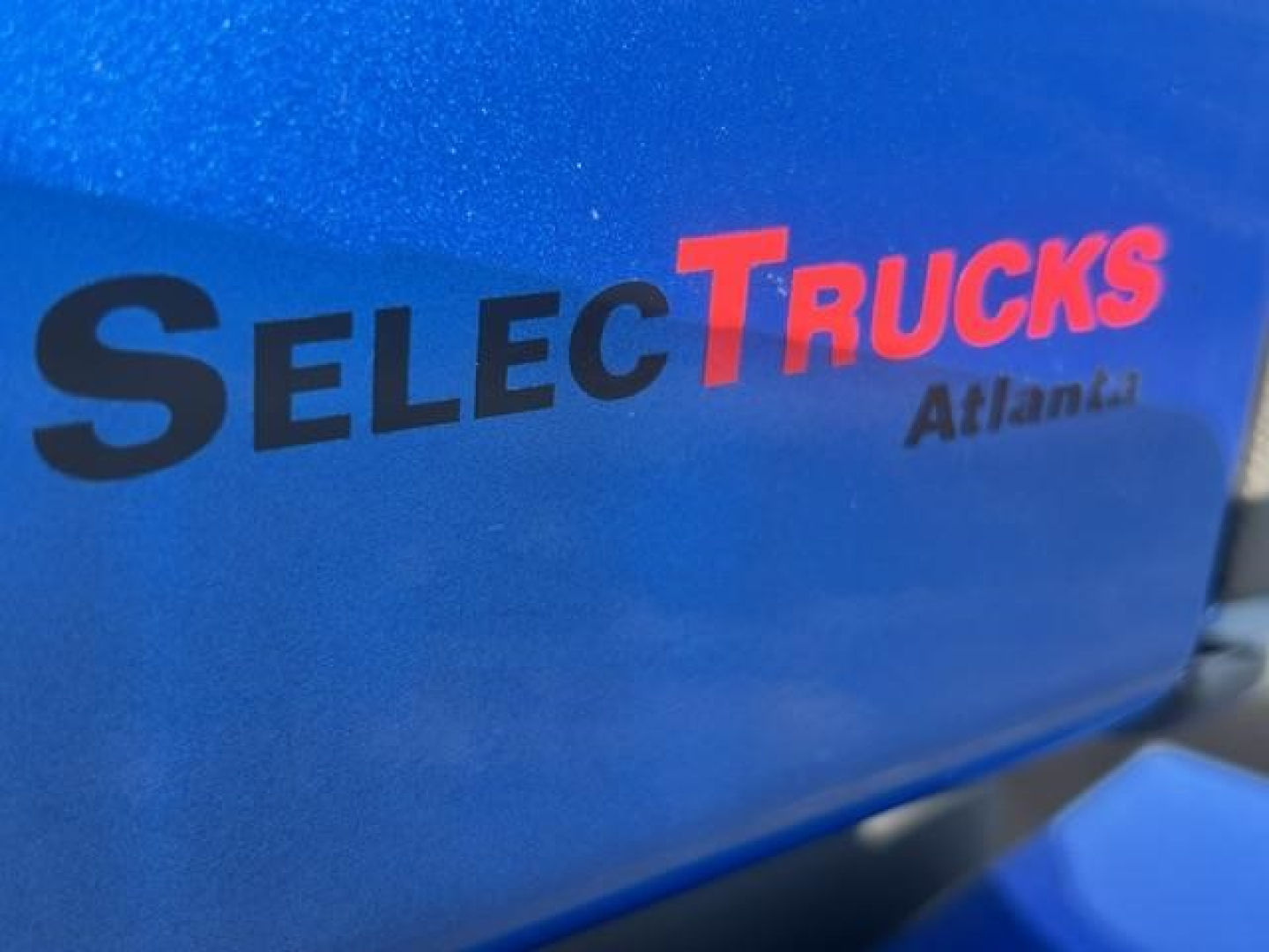 Blue Freightliner Cascadia engine bay cover with SelecTrucks Atlanta logo visible.