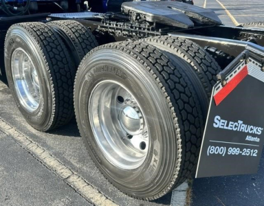 Freightliner Cascadia 126 tractor rear dual wheels and fuel/sleeper area visible with chrome wheels and heavy tires.