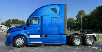 Freightliner Cascadia 126 left side profile showing blue sleeper cab and tandem rear axles with chrome wheels.