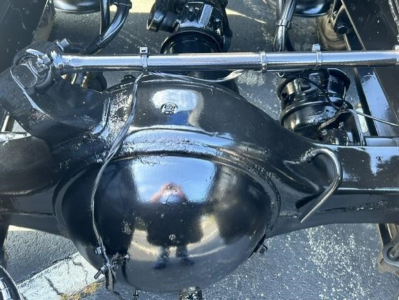 Axle housing and suspension components of a Freightliner Cascadia rear view showing a black-painted differential housing and surrounding driveline hardware.