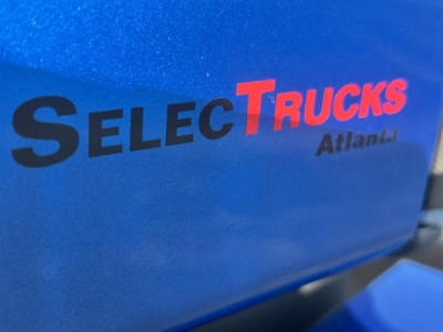 Blue Freightliner Cascadia engine bay cover with SelecTrucks Atlanta logo visible.