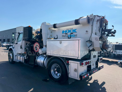 Vehicle side view of a 2018 Freightliner Vactor vacuum truck showing Vactor HXX Paradigm branding and vacuum equipment with rear storage compartments.