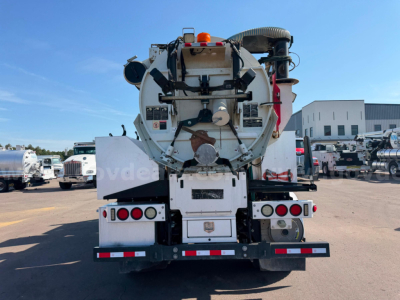 Rear view of a 2018 Freightliner Vactor vacuum truck showing rear-mounted tank and hose reel with warning lights and reflective bumper.