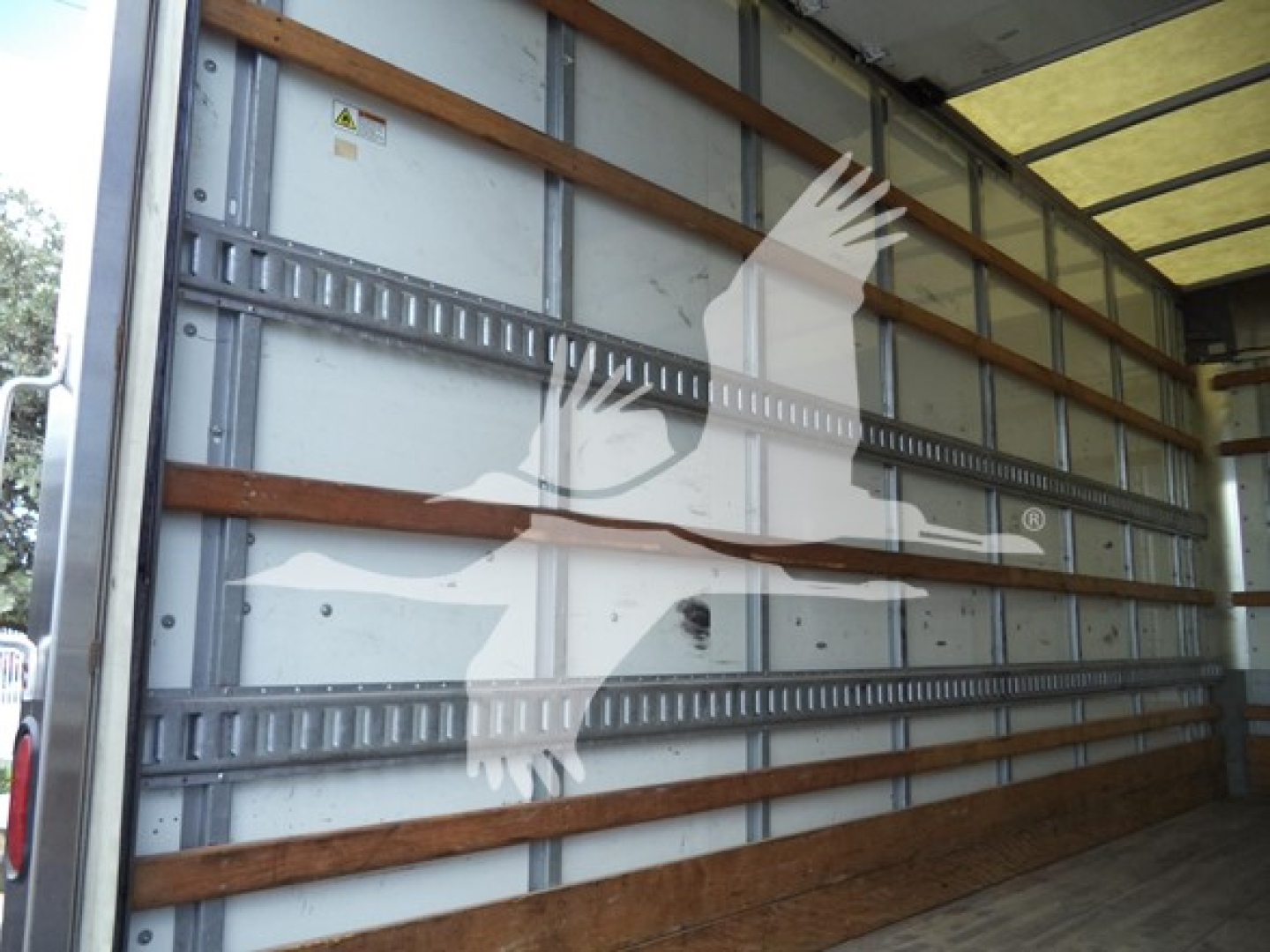 Isuzu NPR box truck cargo area interior with metal side walls and wooden support strips.