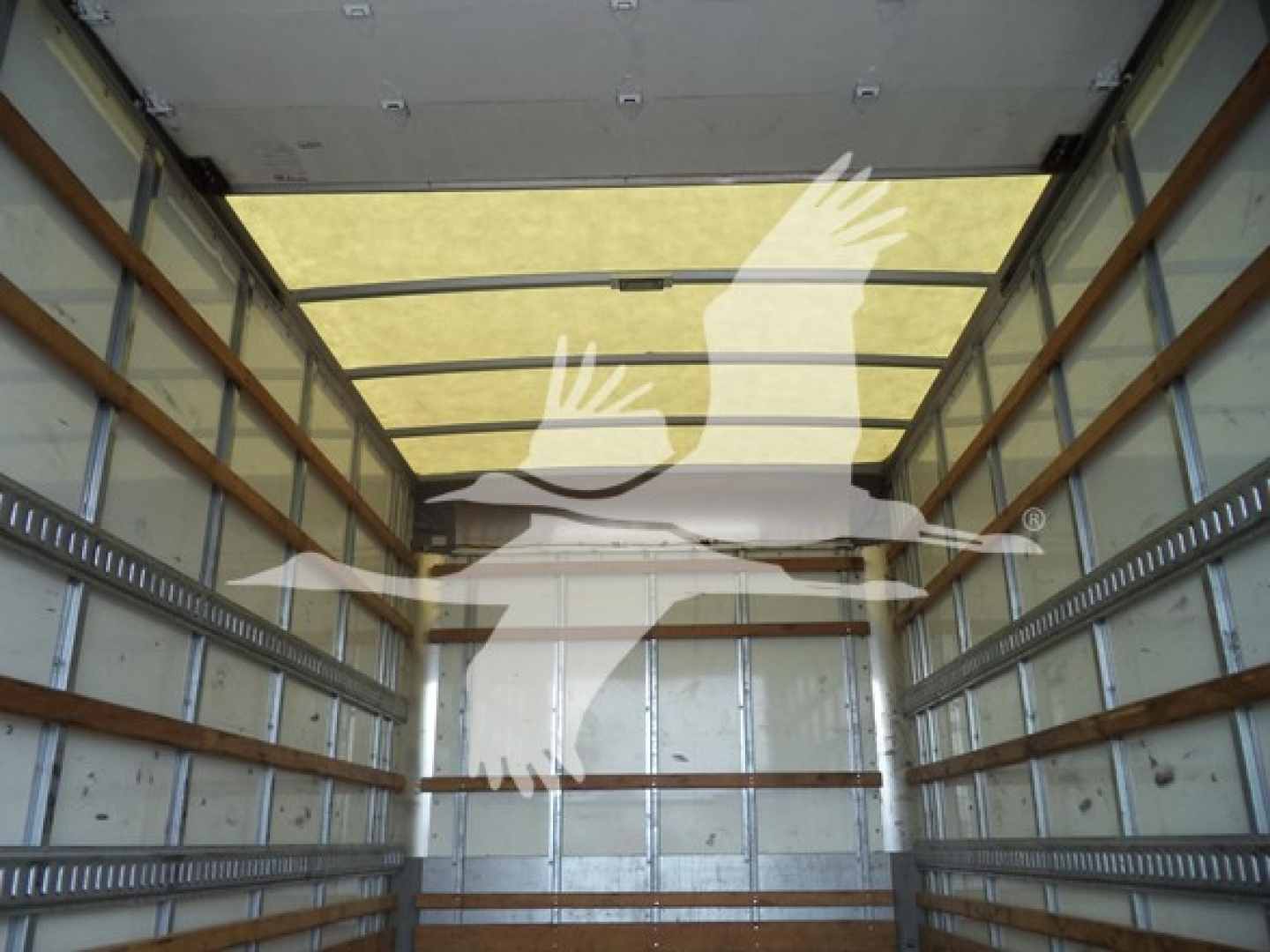 Isuzu NPR box truck interior showing cargo area with metal walls and wooden load rails.