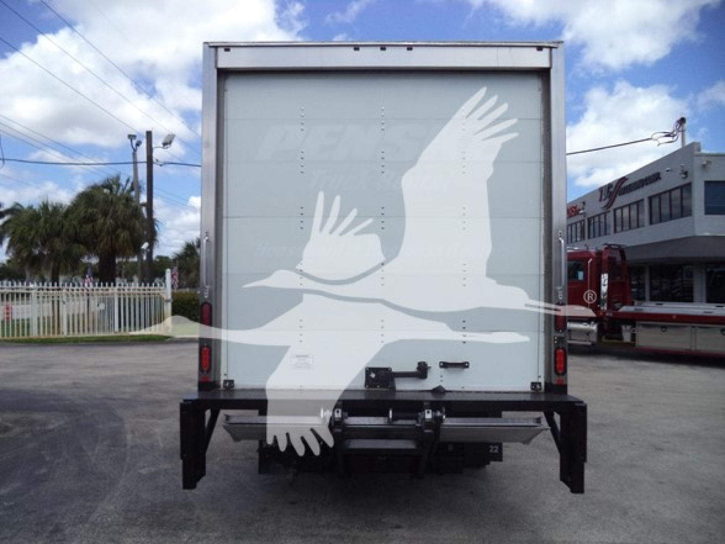 Rear view of a box truck showing a white bird graphic on the back doors.