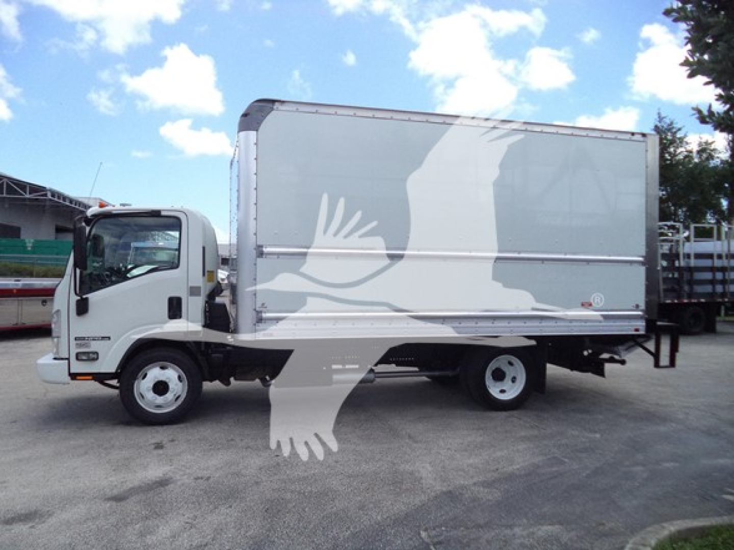 Isuzu NPR box truck side view showing cargo box with graphic overlay and cab; no legible text visible.